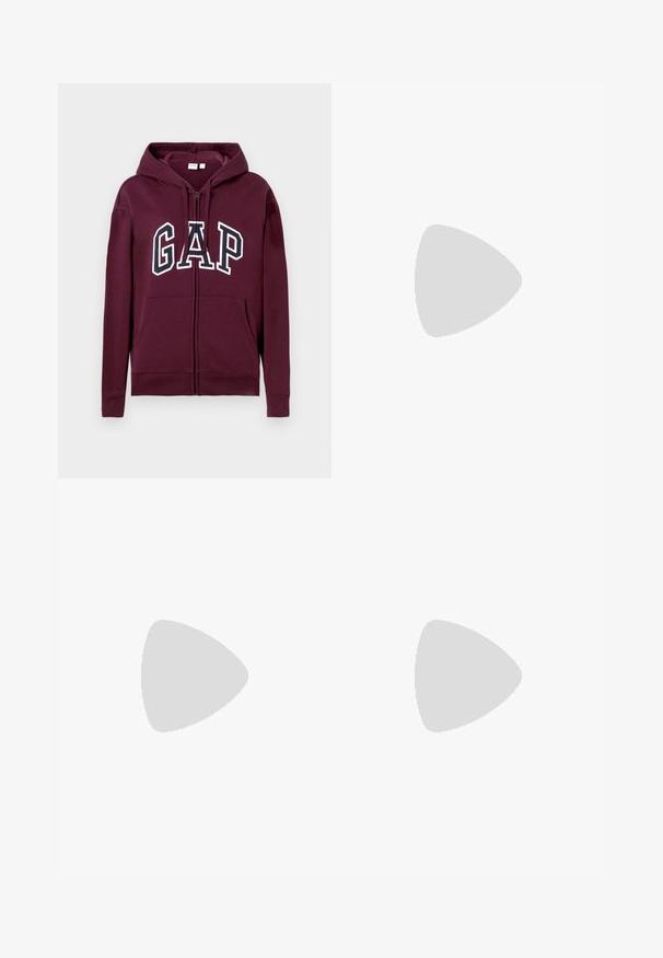 Sweat à capuche zippé bordeaux avec poches avant et logo "GAP" en grandes lettres blanches et bleu marine sur la poitrine, avec une capuche ajustable.; Crop top noir en maille tricotée avec encolure halter, motif vertical en maille ajourée et fermeture par lien au niveau du cou.; Shorts en denim bleu foncé avec une fermeture à bouton et zip, poches avant et bords d'ourlet bruts sur un fond clair.; Baskets de sport gris clair avec une tige en mesh et synthétique, dotées d'un système de laçage, d'un col rembourré et d'une semelle texturée pour une meilleure adhérence.
