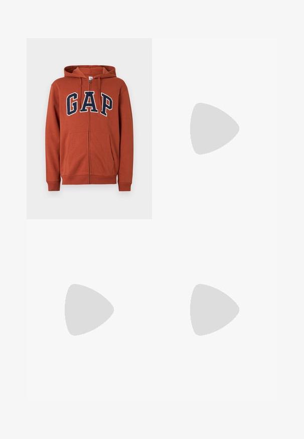 Sweat à capuche zippé couleur rouille, avec poches avant et lettres "GAP" bleu marine soulignées de blanc sur la poitrine.; T-shirt blanc à manches courtes et col rond avec un petit texte noir et rouge indiquant "GOOD MUSIC Sound of Soul" sur la partie supérieure gauche de la poitrine.; Jean en denim bleu foncé à jambes droites avec poches avant et arrière, un bouton et des passants pour ceinture.; Baskets beiges à lacets flottant au-dessus d'un tapis texturé avec une table basse en bois et des livres empilés en arrière-plan flou.
