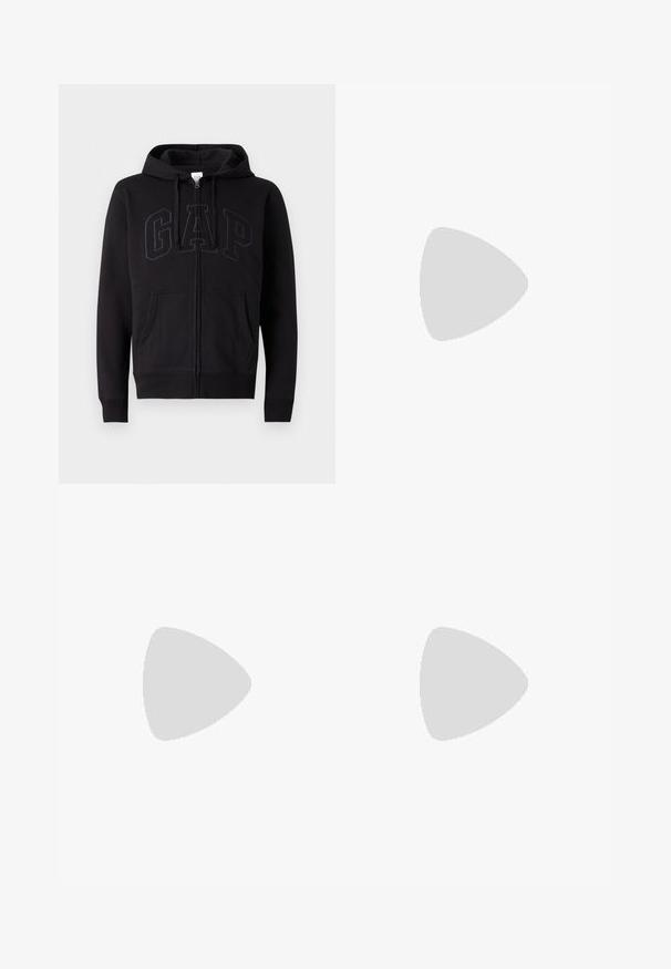 Sweat à zip noir en mélange de coton. Dispose d'une poche kangourou, d'une capuche avec cordon de serrage et d'un grand logo GAP à l'avant en gris foncé.; T-shirt noir à manches courtes et col rond avec un design uni, présenté à plat sur un fond gris clair.; Pantalons noirs à jambe droite avec poches avant, fermeture par bouton et passants de ceinture, présentés sur un fond blanc.; Sneaker en dentelle blanche flottant au-dessus d'un banc en bois avec un feuillage vert en arrière-plan, mettant en valeur le design et la texture de la chaussure.