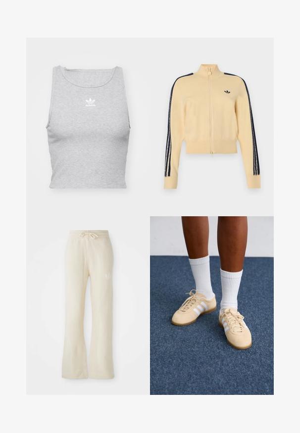 Beige trainingsjack met rits en hoge kraag, zwart Adidas trefoil-logo op de borst en drie zwarte strepen langs elke mouw.; Grijze, mouwloze crop top gemaakt van een zachte stof, met een ronde halslijn en een klein wit Adidas-logo op de borst.; Crème kleurige sweatpants met een zachte textuur, voorzien van een trekkoord tailleband en brede pijpen. Subtiele logo detail op de linkse heup.; Persoon in beige Adidas sneakers met witte strepen en witte enkelsokken, staande op een blauwe tapijtvloer.