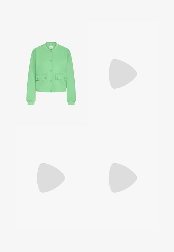Groene cropped jas van zachte stof, met een ronde hals, drukknoopsluiting aan de voorkant en twee voorzakken met kleppen.; Zwart mouwloos jurk met dunne bandjes, aansluitend ontwerp, gemaakt van gladde stof, knielang met een eenvoudige, onversierde stijl.; Zwarte hoge sneaker met witte veters en rubberen zool, balancerend op de rand van een grijs betonnen platform.; Zwarte vierkante zonnebril met donker groene lenzen, uitgerust met gedurfde monturen en zilveren accenten aan de zijkanten. Gemaakt in Italië.
