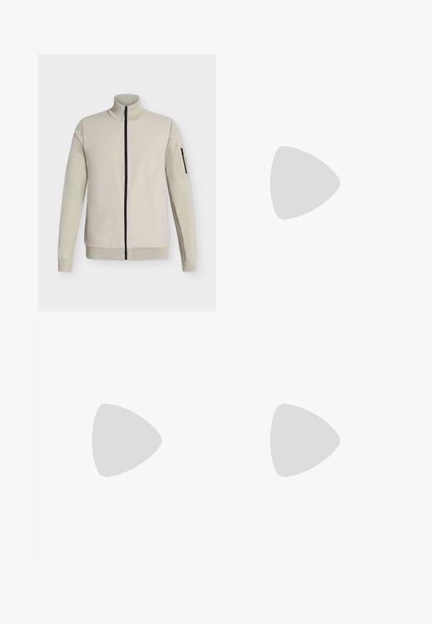 Beige Jacke mit durchgehendem Reißverschluss, mit geripptem Kragen, Bündchen und Saum, ausgestattet mit einer Reißverschlusstasche am linken Ärmel.; Weißes T-Shirt mit kurzen Ärmeln und Rundhalsausschnitt, vorne in der Mitte mit "calvin KLEIN NEW YORK" in Schwarz bedruckt.; Beige Cargo-Hosen mit elastischem Bund und Kordelzug. Sie verfügen über Seitentaschen und ein schmal zulaufendes Bein, gefertigt aus leichtem Stoff.; Ein einzelner grauer Wildleder-Slipper mit weißer Sohle und silbernem Schnallendetail, schwebend über einem hellen Teppich und Holzmöbeln vorgeführt.
