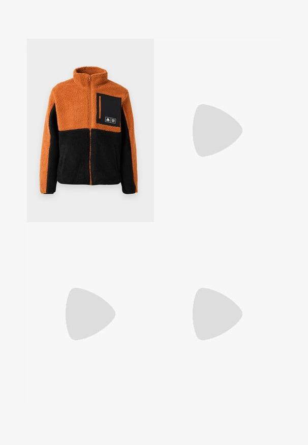 Veste en polaire avec un bloc de couleurs orange et noir, fermeture éclair intégrale, col montant, et une poche poitrine noire avec fermeture éclair et détail de logo.; T-shirt en coton blanc avec encolure ronde, manches courtes et une poche poitrine ornée d'un patch logo noir. Texture lisse, coupe décontractée.; Pantalons en nylon marron avec une ceinture élastique. Présente un logo Timberland vertical en beige clair. Texture lisse, zips aux chevilles pour ajustement.; Baskets Nike Air Max noires et grises flottant au-dessus de marches en béton gris avec un fond de sol texturé.