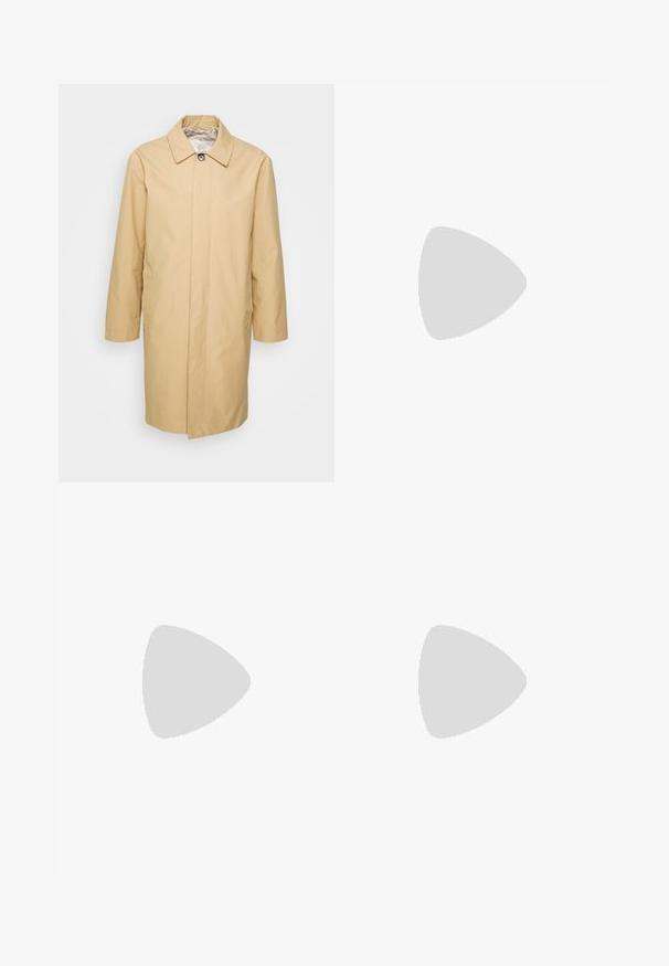 Béžový trench coat po kolená s gombíkovým golierom, dlhými rukávmi a dvoma bočnými vreckami. Hladký, vodoodpudivý materiál.; Hnedý rolák vyrobený z mäkkého materiálu, s dlhými rukávmi, priliehavým strihom a rebrovanými akcentmi na golieri a leme.; Svetlomodré denimové nohavice so rovnými nohavicami, vysokým pásom, dizajnom s piatimi vreckami a viditeľnými stehovými detailmi na švoch a lemoch.; Svetlobéžové semišové Chelsea čižmy s tmavými elastickými bočnými panelmi nosené s tmavými vyhrnutými rifľami na čiernej škvrnatej podlahe.