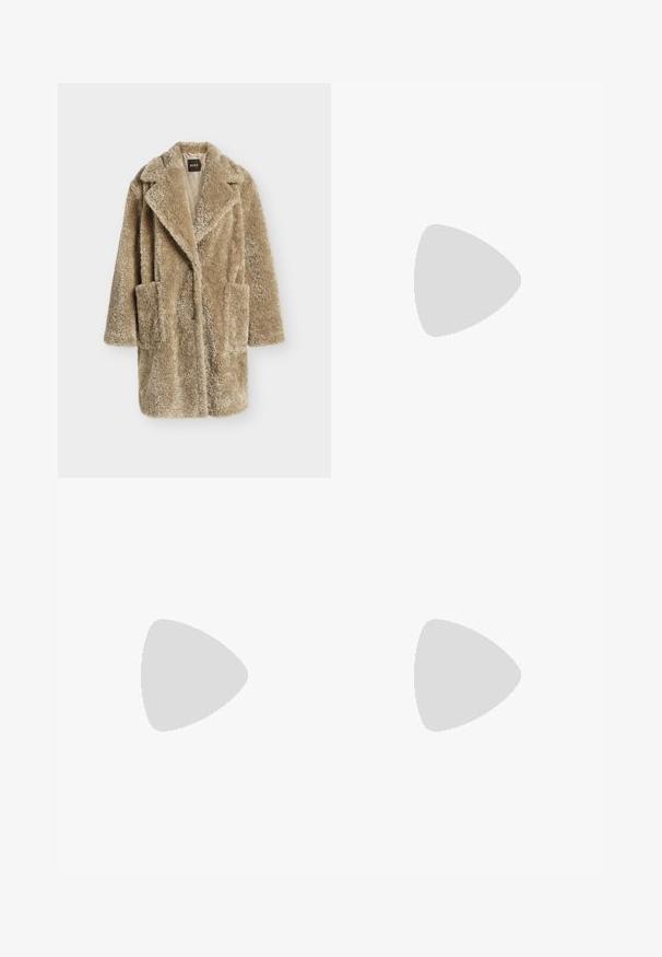 Lange beige jas van nepbont met brede revers, twee voorzakken en een doorgestikte voering met Boss-label.; Roomkleurig T-shirt met korte mouwen en een ronde hals, met een klein geborduurd logo op de linkerborst en een zwart "BOSS"-label aan de binnenkant van de kraag.; Donkergrijze wijde broek met een gestructureerde stof, voorzien van voorplooien en een klassiek taillebandontwerp. Geen zichtbare zakken.; Zwart leren enkellaars met puntige neus en lage kittenhak op lichte achtergrond, zijaanzicht buitenkant.