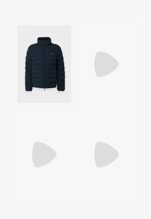 Schwarze gesteppte Jacke mit Stehkragen und Frontreißverschluss, mit einem kleinen weißen Calvin Klein Logo auf der Brust.; Oranger Pullover mit langen Ärmeln, Rundhalsausschnitt, gerippten Bündchen und Saum, weicher Textur und einem kleinen Logo auf der Brust. Leichtes Strickgewebe.; Beige Hosen aus einem Baumwollmischgewebe. Sie verfügen über eine normale Taille, Fronttaschen und einen Reißverschluss mit einem Metallknopfverschluss.; Beiger lässiger Schnürschuh schwebt über einem strukturierten Teppich mit einem beigen, geschwungenen Sofa im Hintergrund.