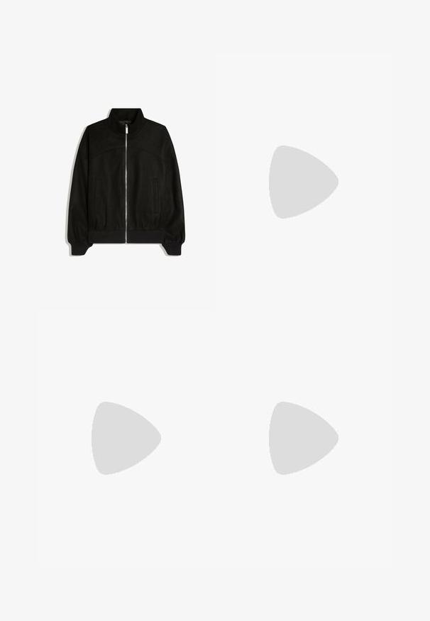 Zwarte jas met rits, hoge kraag, lange mouwen, twee zijzakken en geribde boorden en zoom.; Zwarte katoenen t-shirt, korte mouwen, ronde hals, lichtgewicht, losse pasvorm, gladde textuur, geen zichtbare patronen of accenten.; Zwarte broeken met een recht model, gemaakt van een gladde stof. Voorzien van een voorplooien en een enkele knoopsluiting bij de taille.; Zwarte leren loafer zwevend boven een beige tapijt met een beige bank op de achtergrond, met een klassiek mannenmodel instapontwerp.