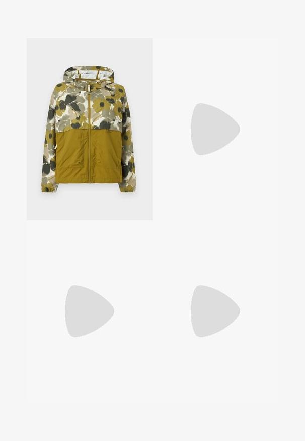 Veste à capuche avec fermeture éclair frontale, moitié inférieure vert olive, moitié supérieure et manches à imprimé floral dans des tons verts doux, beige et noir.; T-shirt blanc à manches courtes, col rond, avec un petit logo "The North Face" bordeaux sur la partie supérieure gauche de la poitrine.; Pantalon cargo vert clair à jambes larges avec taille élastique et cordon de serrage, doté de poches latérales à rabat et d'une coupe décontractée.; Des chaussures beiges avec des lacets rouges, posées sur une surface bleue texturée, révèlent partiellement la cheville d'une personne. Les chaussures ont un design sportif.