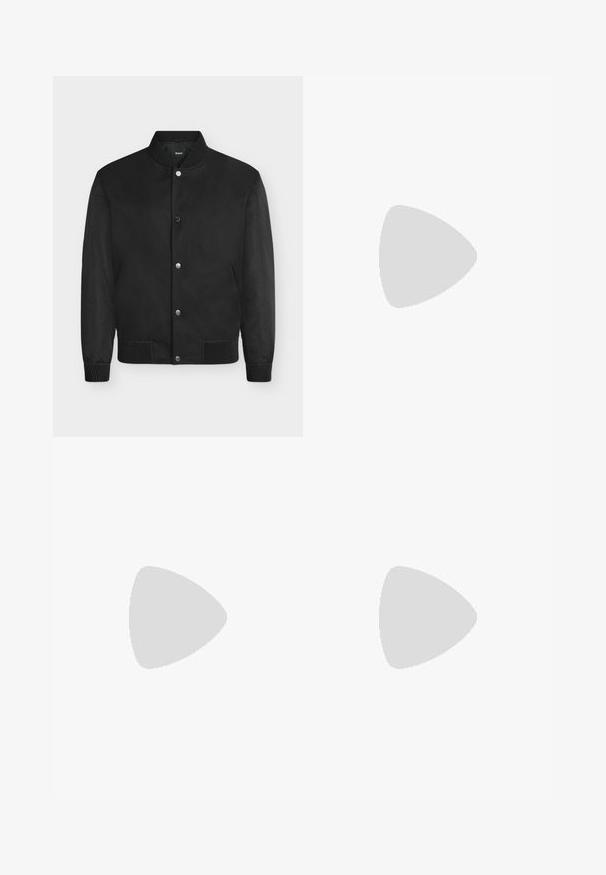 Blouson bomber noir avec col, poignets et ourlet côtelés, boutons-pression et manches texturées.; T-shirt noir à manches courtes et col rond avec un petit patch logo rectangulaire sur la poitrine gauche et une bordure intérieure verte au col.; Pantalon de jogging noir avec taille élastique et poignets aux chevilles, équipé d'une petite fermeture éclair latérale et d'un logo discret de la marque sur la jambe droite.; Chaussure habillée noire en cuir à lacets avec devant texturé, flottant au-dessus d'un tapis beige dans une pièce moderne avec des meubles teintés d'ambre.