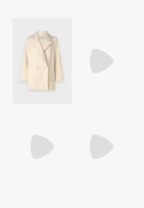 Cremefarvet dobbeltradet frakke med klapkrave, sidelommer og lyse knapper. Glat, struktureret stof med minimal tekstur.; Kortærmet beige sweater lavet af tekstureret strik. Har lodret ribbning og en høj halsudskæring. Blødt stof med subtil glans.; Beige bukser med lige pasform, der har en dobbelt manchet i kanten og en flad frontdesign. Lavet af glat, slidstærkt stof.; Sort læderankelstøvle med spids tå og lille hæl vist mod en væg af glasblokke og poleret gulv baggrund.