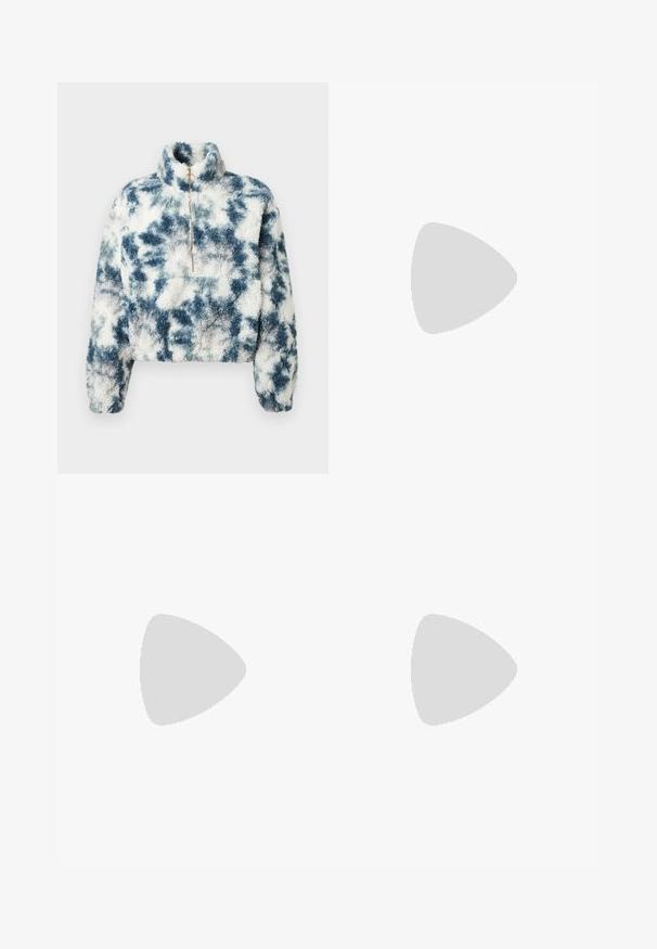 Πουλόβερ fleece σε μπλε και λευκό tie-dye σχέδιο με ψηλό γιακά, φερμουάρ ενός τετάρτου και κοντή σχεδίαση. Μαλακή υφή με τετράγωνη εφαρμογή.; Λευκό κοντομάνικο ριμπ T-shirt με στρογγυλή λαιμόκοψη, εφαρμοστή γραμμή και μικρή ετικέτα της μάρκας μέσα στο κολάρο.; Ανοιχτό μπλε τζιν παντελόνι με φαρδιά πόδια, διαθέτει υψηλή μέση, γυριστές μανσέτες, πέντε τσέπες και κλείσιμο με κουμπί και φερμουάρ.; Πόδια με σκουρόχρωμα ριμπ κολάν συνδυασμένα με μαύρα μπαλαρίνα παπούτσια με μικρές λεπτομέρειες φιόγκων σε λευκό φόντο.