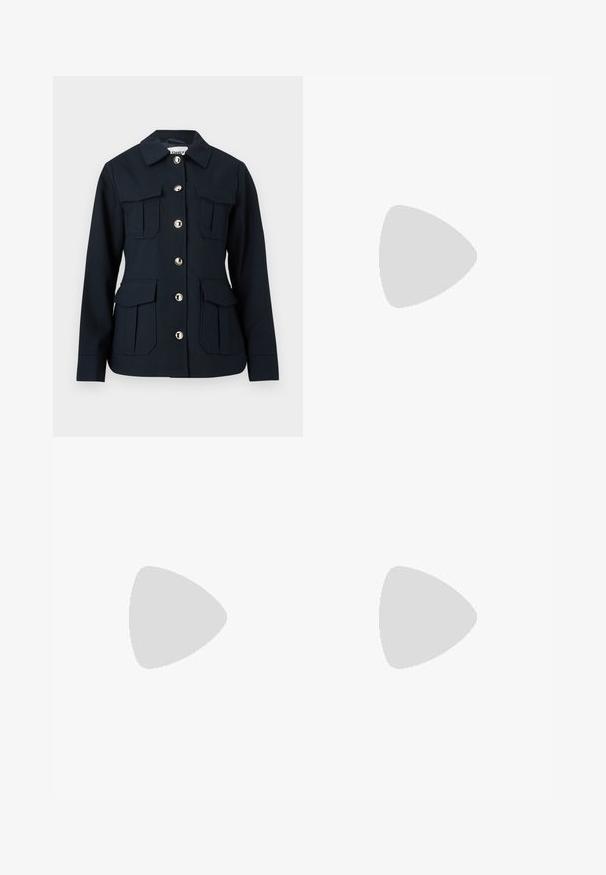 Veste bleu marine à manches longues, fermeture à boutons sur le devant, quatre grandes poches à rabat, et col classique.; Pull en tricot blanc avec des motifs géométriques noirs et roses sur la poitrine, les manches et l'ourlet, présentant un col rond et des poignets côtelés.; Jeans en denim bleu foncé à jambes larges, avec une taille haute, quatre poches et des coutures contrastantes le long des coutures.; Baskets en daim et cuir noir avec un swoosh latéral crème et un talon crème clair. Dotées de lacets beige et d'une semelle en caoutchouc gomme.