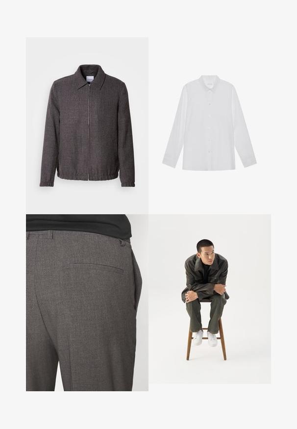Lindbergh TEXTURED ZIP THROUGHT JACKET - Kevyt takki - charcoal; Valkoinen pitkähihaisen paita, valmistettu sileästä kankaasta, jossa on terävä kaulus, etupainonappi kiinnitys ja yksinappi hihansuut.; Harmaat räätälöidyt housut, joissa on sileä pinta, yhden takataskun ja slim fit -muotoilu. Kankaassa on hienovarainen kuvio.; Nuori mies tummassa nahkatakissa ja farkuissa istuu puisella jakkaralla, nojaa eteenpäin käsivarret ristissä ja katsoo sivulle valkoista taustaa vasten.