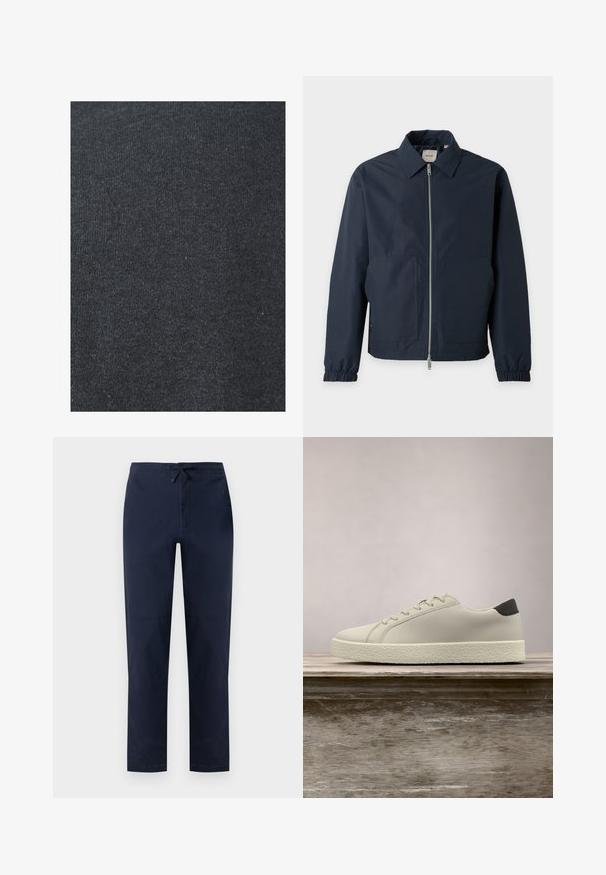 Veste légère bleu marine avec fermeture éclair à l'avant, col pointu, poignets élastiques et deux grandes poches avant.; Tissu en coton noir avec une texture lisse, présentant un motif de tricot uniforme et sans embellissements ni détails en métal visibles.; Pantalon droit bleu marine avec devant plat, poches latérales et taille élastique munie d'une patte noire ajustable.; Baskets blanches avec semelle texturée et détail noir au talon, flottant au-dessus d'un banc en bois avec de hautes herbes vertes en arrière-plan.