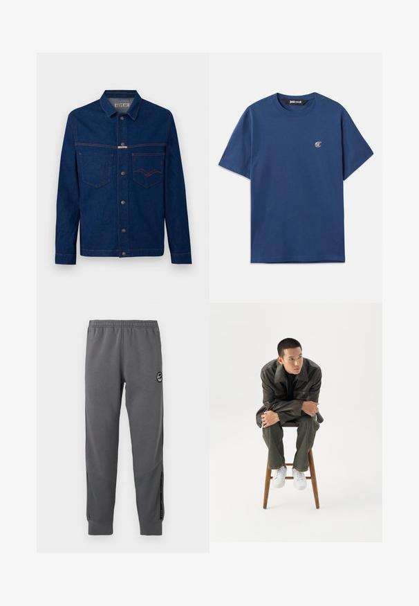 Donkerblauwe denimjas met lange mouwen, knoopsluiting aan de voorkant, borstzakken en contraststiksels in oranje, met het label Replay op de kraag en zak.; Navyblauwe katoenen T-shirt met een ronde hals, korte mouwen en een klein ovaal logo op de linkerborst. Glad textuur, casual pasvorm.; Grijze sweatpants van zacht materiaal met een elastische tailleband, taps toelopende benen, zijpanelen en een ronde logo patch.; Jonge man in een donkere leren jas en spijkerbroek zit op een houten kruk, leunt naar voren met gekruiste armen en kijkt naar de zijkant tegen een witte achtergrond.