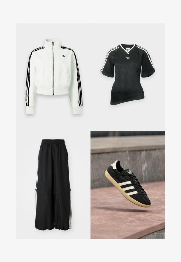 Hvid cropped jakke med høj krave, frontlynlås, sorte stribede detaljer på ærmerne og en lille sort logo på brystet.; Sort atletisk skjorte med V-hals, korte ærmer og tekstureret chevronmønster. Har hvide tre-stribe accenter på skuldrene og logo.; Sorte atletiske bukser med elastisk talje, sidelæns striber og en løs pasform med en samlet kant for en luftig silhuet.; Sort Adidas sneaker med hvide striber og beige sål, fanget i luften over en stenet overflade og baggrund af en stenmur.