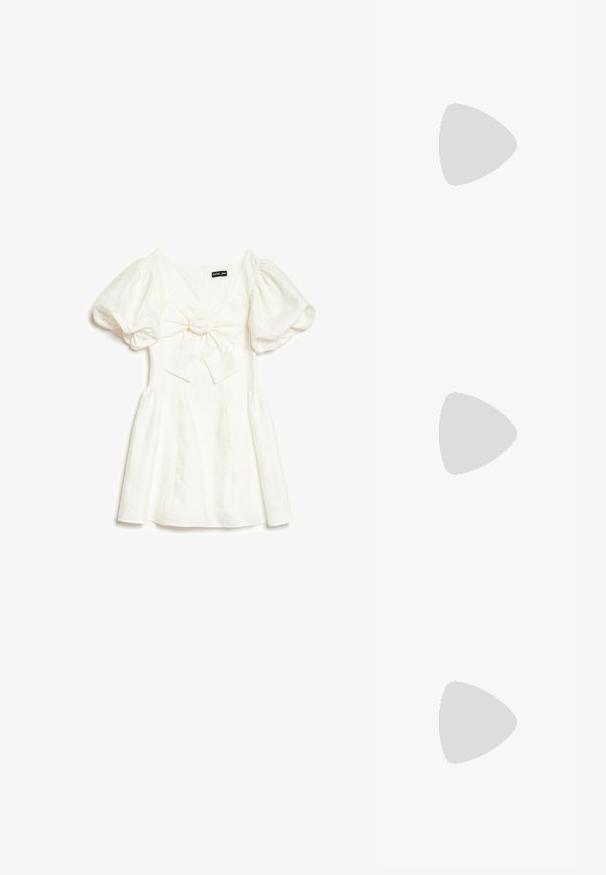 Witte korte jurk met pofmouwen en een grote strik voorop, gelabeld Sister Jane, plat gelegd op een witte achtergrond.; Zwarte lakleren Mary Jane-hakken met een spitse neus, een middelgrote blokhak en een decoratieve gouden gesp op de band.; Witte doorgestikte handtas met parelversieringen, parelhandvat, kleine strik en gouden ronde gesp op een witte achtergrond.; Parelketting bestaande uit een enkele streng witte parels, afgewisseld met kleine gouden kralen, afgerond met een gouden sluiting.