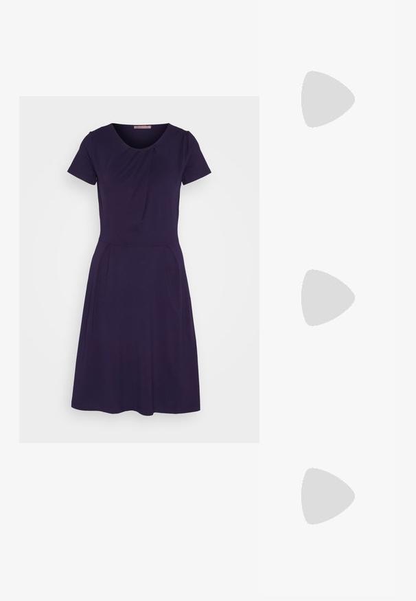 Dunkellila kurzes Kleid mit kurzen Ärmeln und rundem Ausschnitt, subtilen Falten an der Brust und Taille sowie einem schwingenden A-Linien-Rock. Weicher Stoff.; Schwarzer Slingback-Schuh aus Lackleder mit spitzer Kappe, niedrigem Blockabsatz und silberfarbenem Schmuckdetail vorne.; Schwarze Handtasche aus glattem Material mit doppelten Griffen und einem abnehmbaren Schultergurt. Ausgestattet mit einem Vorderdeckel und einem Akzent aus einem seidenen Schal mit Blumenmuster.; Silberne Steckerohrringe mit einem kreisförmigen Design, umgeben von klaren Strasssteinen, mit einer glatten Metalloberfläche.