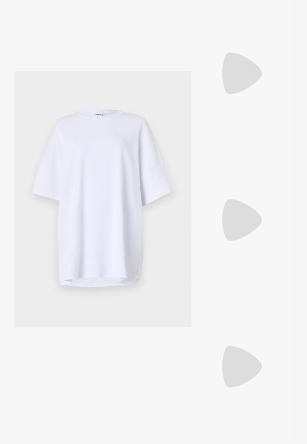 Oversized, kurzärmliges weißes T-Shirt aus Baumwolle. Runder Halsausschnitt, Seitenschlitze am Saum und glatte Textur ohne sichtbare Muster oder Akzente.; Laufschuhe mit einem atmungsaktiven weißen Mesh-Obermaterial, silbernen Akzenten, grauen Schnürsenkeln und einer langlebigen schwarzen Gummisohle. Leichtes, gepolstertes Design.; Schwarze rechteckige Sonnenbrillen mit dunklen Gläsern und dicken matten Rahmen. Die Bügel sind leicht verjüngt und haben eine glatte Oberfläche.; Person trägt braune weite Hose und weißes Oberteil und hält eine große schwarze weiche Handtasche an der Seite am Trageriemen.