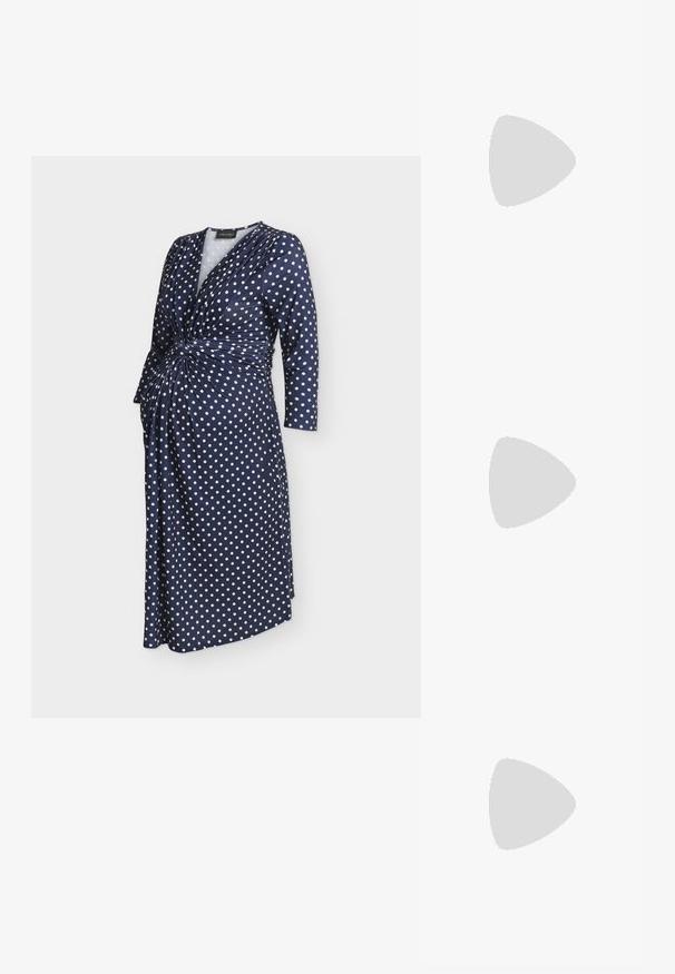 Marineblå slå-om-kjole med hvide prikker, lange ærmer og indsamlet knudedetalje ved taljen.; Hvid læder højhælet sko med spids tå og en slank, let skrå hæl. Glat tekstur med et minimalistisk design og tan sål.; Brun håndtaske med guldlås, pink mønstret stofombundet håndtag, aftagelig rem og guldfarvede blomsterformede kædecharms.; Perlekæde med sølvlås og hjerteformet klart krystalvedhæng, der hænger i midten.
