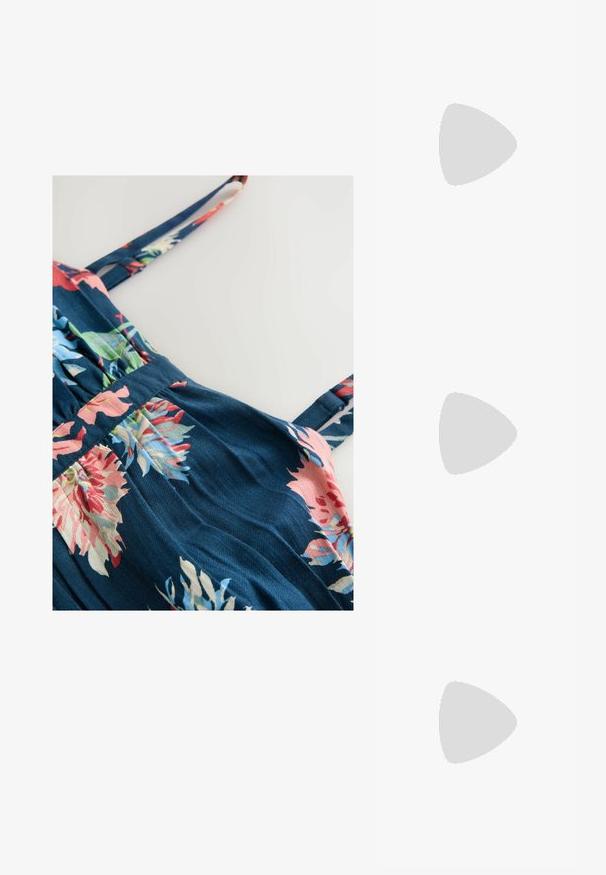 Blomstret kjole i marineblå stof. Har tynde stropper, plisseret talje og livlige mønstre af pink, rød og grønne blomster. Blød tekstur.; Hvide patentlæder slingback sko med spidse tæer og en geometrisk blokhæl. Indersiden har en tan indersål og minimale udskæringer på siden.; Sort, hvid og beige håndtaske med guldlås og kæde, dekoreret med en stor hvid silkebue med sorte prikker på håndtaget.; Fin perle halskæde med små runde perler og gyldent låsespænde med en dekorativ rund vedhæng.