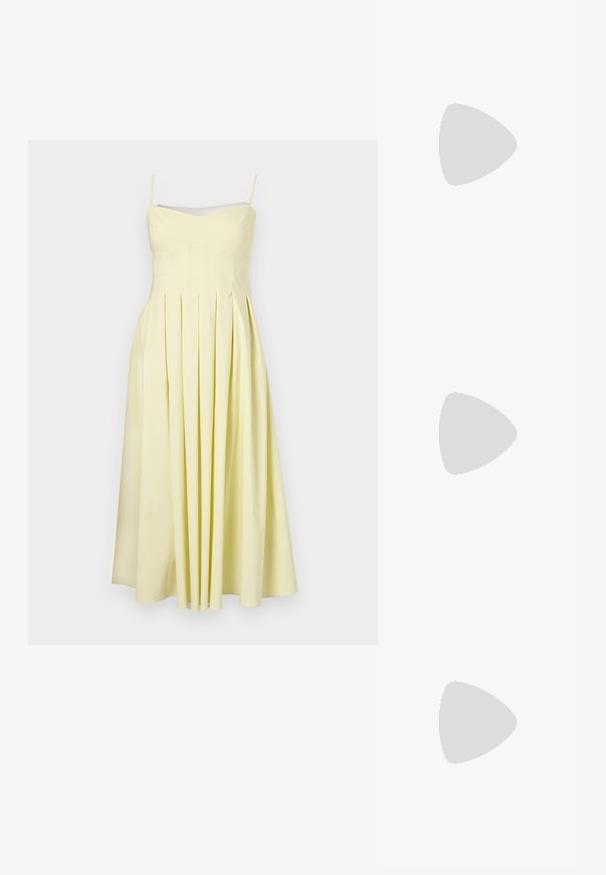 Vestido amarillo plisado con tirantes de espagueti ajustables y un cuerpo ajustado, con una textura suave y falda fluida hasta la mitad de la pantorrilla.; Bailarinas de cuero negro con punta afilada, suela plana y una pequeña correa con detalle de hebilla plateada.; Bolso de hombro blanco de Calvin Klein con asas largas, forma rectangular, cierre de cremallera y charm decorativo con el logo colgando cerca del asa.; Pulseras metálicas pulidas entrelazadas en tonos plateados y dorados, una grabada con el logo "Calvin Klein", sobre un fondo blanco.