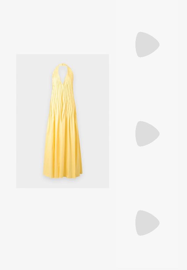 Κίτρινο μάξι φόρεμα με halter neck, βαθύ V-ντεκολτέ και κάθετες πιέτες στο μπούστο, που καταλήγει σε υφασμάτινη, μακριά φούστα.; Σκούρο καφέ επίπεδη σαγιονάρα με υφασμένους ιμάντες, πόρπη στον αστράγαλο και ανοιχτή μύτη πάνω σε απλό φωτεινό φόντο.; Ορθογώνια τσάντα με κίτρινο και μαύρο λουλουδάτο σχέδιο και πλεκτή κίτρινη και ροζ χειρολαβή σε λευκό φόντο.; Ζευγάρι μακριά, λεία, λαμπερά χρυσά σκουλαρίκια σε σχήμα δάκρυου με στρογγυλεμένες κορυφές και λεπτό σχήμα σταγονίδας σε ανοιχτό φόντο.
