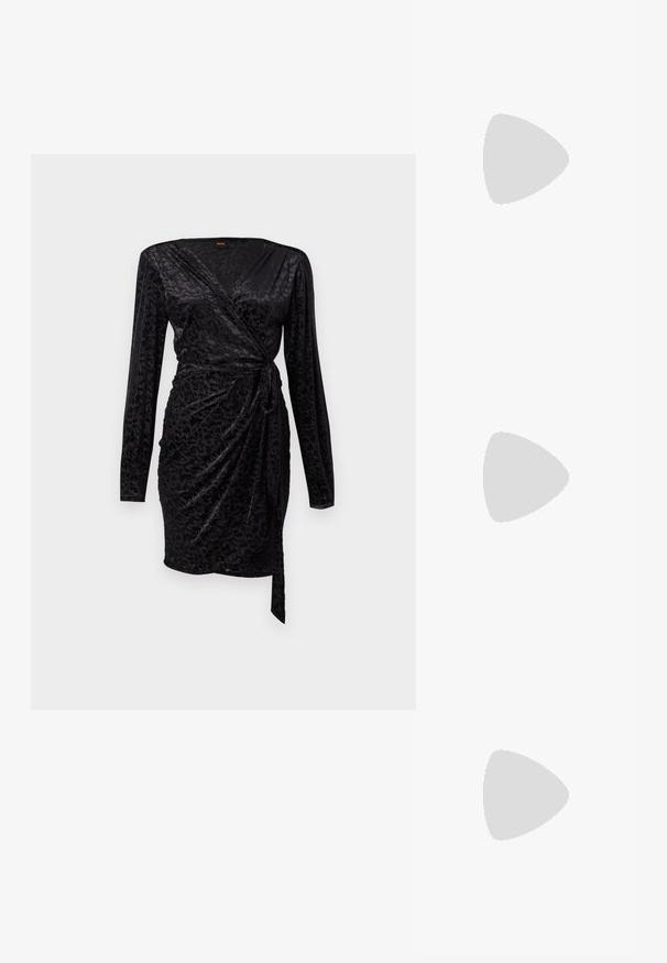 Mustaa käärevärinen mekko, jossa on pitkät hihat, pehmeä tekstuuri, jossa on hienovarainen kuvio, ja sidottu vyötäröyksityiskohta, joka luo muotoillun siluetin.; Mustat korkokengät, joissa nilkkahihna, näyttävät leijuvan puisella laattalattialla ulkona, taustalla sumea vihreä kasvillisuus ja kiviseinä.; Musta nahkainen olkalaukku, jossa on kaareva suorakaiteen muoto, punottuun mustaan hihnaan kudottu kultainen ketju ja yläosan vetoketjusuljin.; Hopeakylkiset korvakorut, joissa on sileät, pyöreät ja heijastavat pinnat, riippuvat leuka-takaklipsuista. Tausta on yksinkertainen valkoinen.