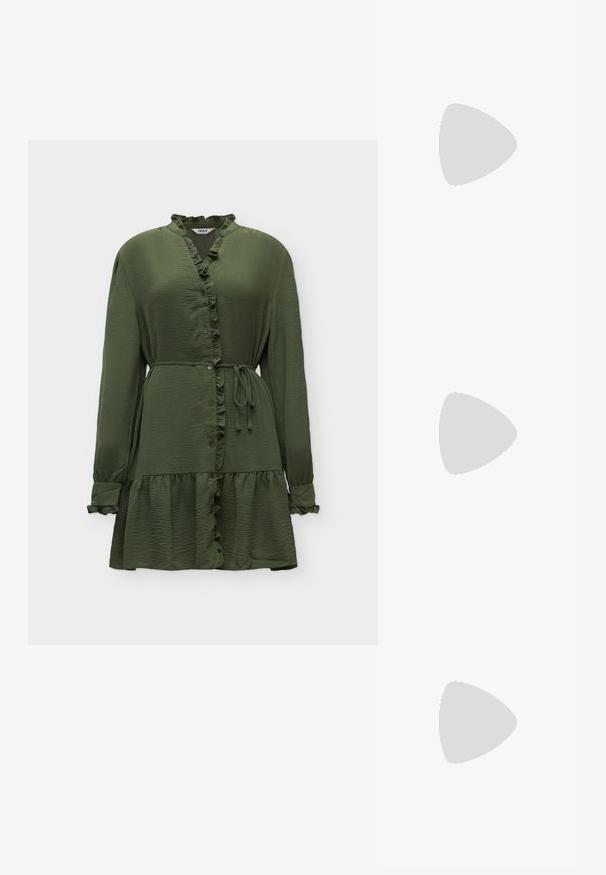 Robe vert olive à manches longues avec col et ourlet volantés, boutonnage devant, ceinture à nouer à la taille sur fond uni.; Jambes portant des leggings côtelés foncés associés à des ballerines noires avec de petits détails en nœud sur fond blanc.; Sac à main en tissu noir doux avec haut froncé et poignées circulaires rembourrées nouées de chaque côté.; Paire de boucles d'oreilles créoles doubles en or brillant avec attaches à tige sur fond blanc.