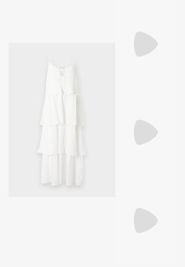 Robe blanche à volants en tissu texturé, avec de fines bretelles spaghetti et un détail noué au niveau du col.; Sandales à talons hauts noires au design élégant, avec deux fines brides sur les orteils et une bride croisée à la cheville avec une boucle.; Sac à main en cuir blanc avec un design plissé, doté d'une bandoulière en chaîne dorée et d'une forme arrondie. Texture lisse avec des plis doux et sans motifs.; Ensemble collier et bracelet ton or avec motifs floraux et feuilles en cristal clair, tous deux avec fermoirs chaîne réglables sur fond blanc.