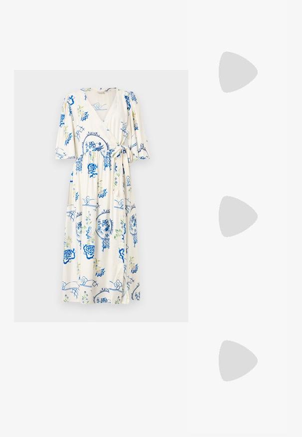 Robe portefeuille en tissu crème clair, ornée de motifs floraux bleus et d'accents verts. Manches bouffantes courtes, détail à nouer à la taille et longueur genou.; Sandale blanche à talon haut avec trois brides à l'avant et une bride de cheville réglable avec une boucle dorée.; Pochette rectangulaire couleur crème avec une bandoulière chaîne dorée posée sur le coin supérieur gauche sur un fond uni.; Boucles d'oreilles droites en or et en argent avec une forme courbe et allongée. Fini brillant avec une texture lisse et un design minimaliste.
