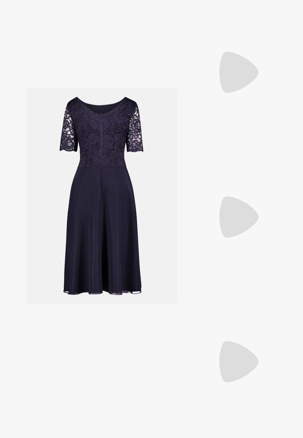 Marineblaues knielanges Kleid mit floraler Spitzenoberseite, halblangen Ärmeln, Rundhalsausschnitt und fließendem einfarbigem Rock.; Weißer Lackleder-Pumps mit offenem Seitenbereich, spitzer Zehenpartie, Knöchelriemen mit Schnalle und blockhaftem Absatz.; Weiße Handtasche aus Kunstleder mit strukturiertem Design, ausgestattet mit einem goldenen Kettenriemen und einer dekorativen Edelsteinverzierung auf der Vorderseite.; Goldfarbene Tropfenohrringe mit einem klaren ovalen Kristall an der Basis, ergänzt durch kleinere Kristalle und florale Details darüber.