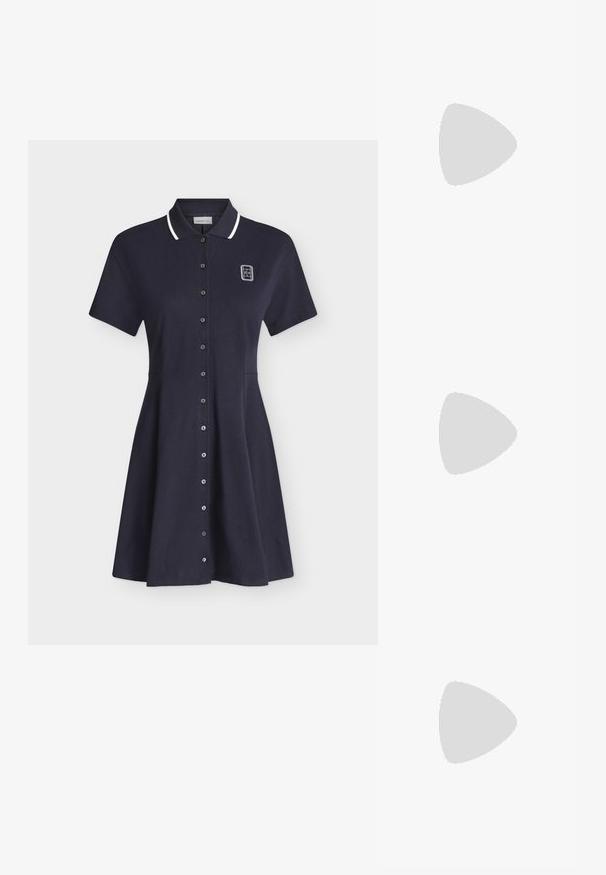 Robe polo bleu marine à manches courtes avec bordure blanche au col, fermeture à boutons sur le devant et petit logo blanc sur la partie supérieure gauche de la poitrine.; Chaussure plate en cuir verni marron avec bout pointu et trois brides ajustables à boucle sur le côté, vue du profil extérieur.; Sac hobo en cuir couleur crème avec une seule bandoulière, texture lisse et un détail de fermoir doré à l'avant.; Ceinture en daim marron avec une large boucle dorée à double cercle ; texture lisse avec des lignes épurées et un design à extrémité effilée.