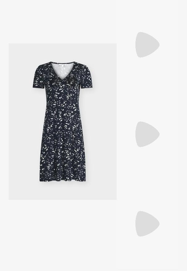 Robe bleu marine mi-longue aux genoux, manches courtes, avec un motif abstrait de points blancs, dotée d'un col en V et d'une taille cintrée.; Chaussure plate Mary Jane en cuir verni noir avec deux découpes et une bride à boucle dorée sur fond blanc.; Sac à main en cuir gris à la forme arrondie, avec des accessoires dorés et un charm décoratif. Il est doté d'une fermeture éclair et d'une seule bandoulière.; Boucle d'oreille en argent avec une finition polie, présentant de petits détails en or et de forme ronde, portée sur le lobe.