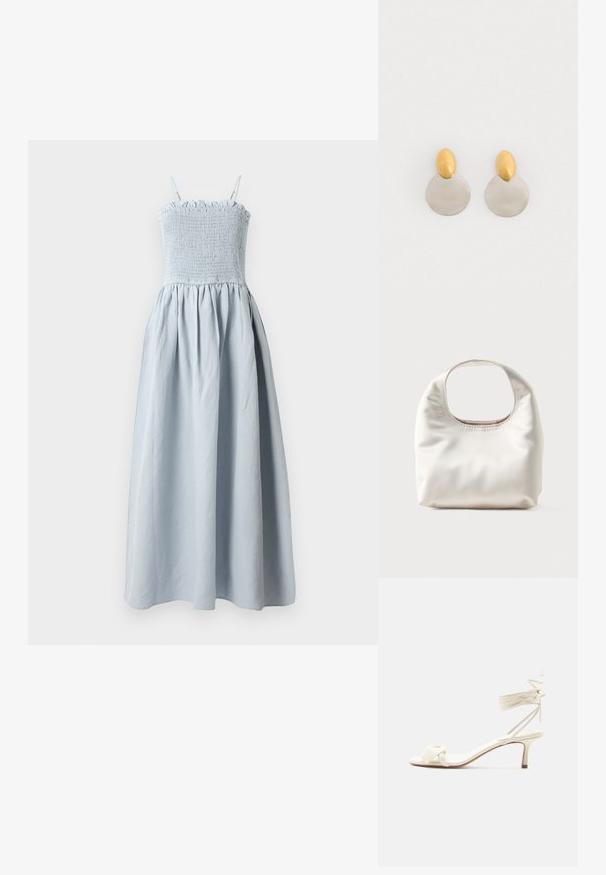 Lichtblauwe, lange katoenen jurk met een smocked bodice, dunne schouderbandjes en een vloeiende, geplooide rok. Bevat een rimpelige bovenrand.; Roomkleurige sandalen met lage hak, enkelriempjes en een brede gedraaide band over de tenen, op een effen witte achtergrond.; Zachte witte handtas met een afgeronde rechthoekige handgreep en een losse, gladde textuur op een lichte achtergrond.; Gouden en zilveren metalen oorbellen met een ronde schijfbasis en een ovale bovenstuk, gladde textuur en gepolijste afwerking.