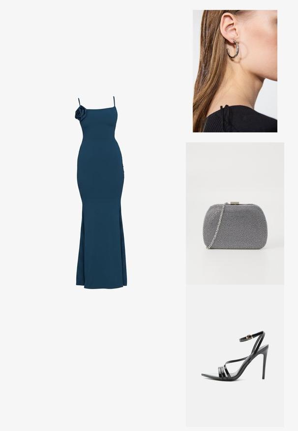 Robe bleu marine longue jusqu'au sol sans manches avec fines bretelles et détail d'une fleur en tissu sur l'épaule gauche, silhouette ajustée.; Sandale noire à talon haut avec de fines brides sur les orteils et la cheville, avec une boucle dorée sur un talon aiguille élancé.; Pochette texturée noir et blanc de forme arrondie, avec une chaîne en métal argenté et un fermoir en métal en haut.; Boucle d'oreille en argent avec une finition polie, présentant de petits détails en or et de forme ronde, portée sur le lobe.