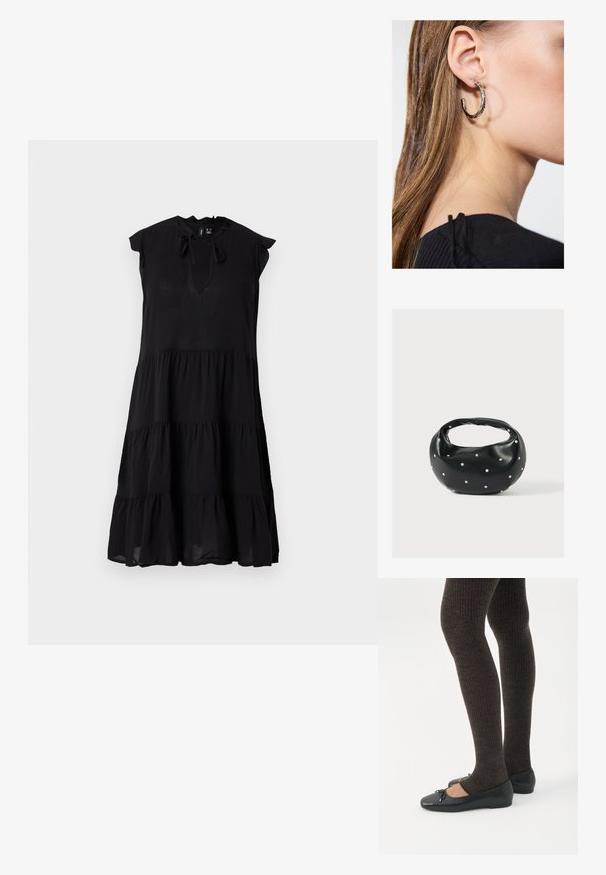 Robe midi noire sans manches à volants avec col froufrou et ouverture devant nouée par un nœud.; Jambes portant des leggings côtelés foncés associés à des ballerines noires avec de petits détails en nœud sur fond blanc.; Sac à main en cuir noir de forme arrondie, décoré de clous argentés et équipé d'une poignée courte. Texture lisse et fermeture éclair.; Boucle d'oreille en argent avec une finition polie, présentant de petits détails en or et de forme ronde, portée sur le lobe.