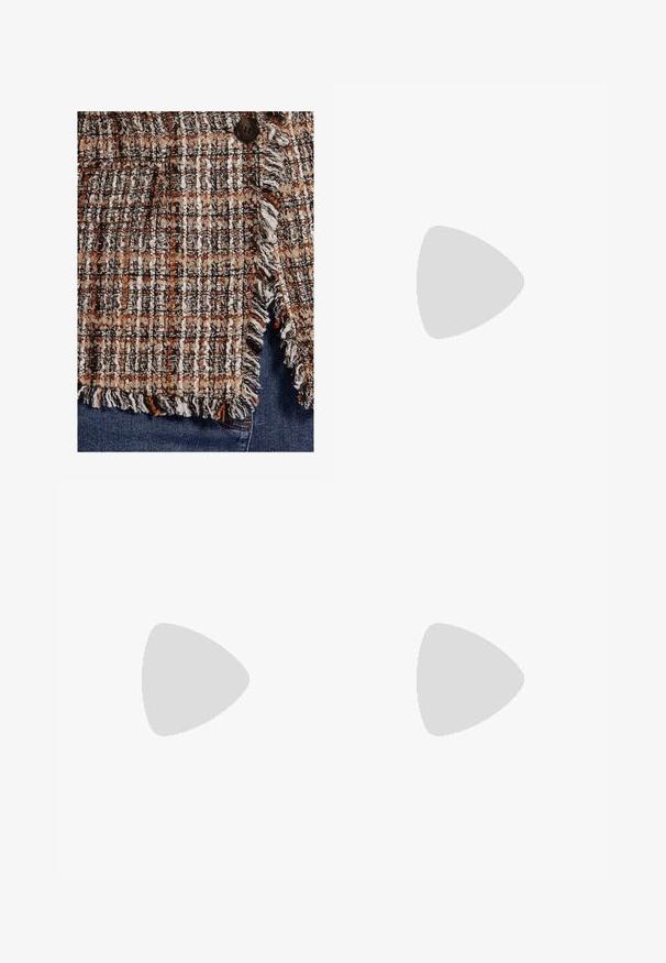Close-up van gestructureerde bruine, zwarte en witte tweedstof met franjes en een donkere knoop op blauwe spijkerbroek.; Crèmekleurige blouse met lange mouwen, hoge kraag en grote gestrikte strik aan de hals, met geplooide schouders en knoopmanchetten.; Wijd uitlopende bruine broek met plooien, riemlussen en een ritssluiting aan de voorkant.; Bruine leren kniehoge laars met een ronde neus, dikke zwarte hak en subtiele stiksels aan de voor- en achterkant.