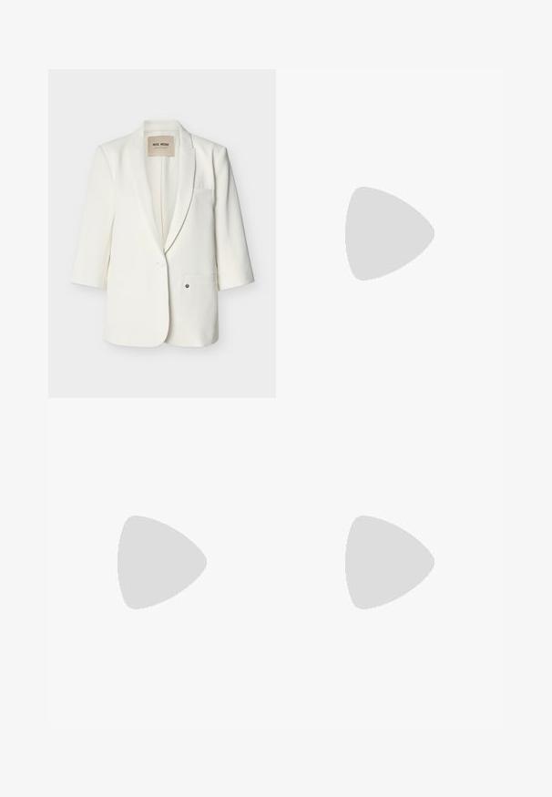 Blazer blanc cintré avec revers crantés, fermeture à un bouton, deux poches avant et manches trois-quarts.; Chemise noire à manches courtes avec col, six boutons sur le devant, et une silhouette légèrement cintrée.; Pantalon noir taille haute à jambes larges, avec passants pour ceinture et fermeture dissimulée à l'avant.; Chaussure noire en cuir à double boucle avec des détails perforés flottant au-dessus d'un banc en bois à l'extérieur avec de l'herbe verte et des plantes en arrière-plan.