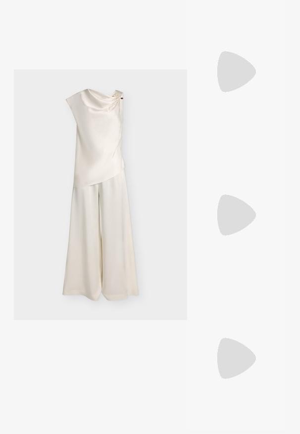 Haut en satin sans manches couleur crème avec encolure drapée et pantalon large assorti sur fond uni.; Cardigan bleu marine en maille torsadée avec bordure blanche sur le col, la patte de boutonnage et les poignets, doté de boutons sur le devant et de manches longues.; Baskets en suède tan au design minimaliste, bout rond et semelle en caoutchouc. Présente deux bandes verticales et un laçage. Texture lisse.; Sac pochette doré avec motif rectangulaire embossé arrondi et une petite chaîne en bandoulière sur un fond uni.