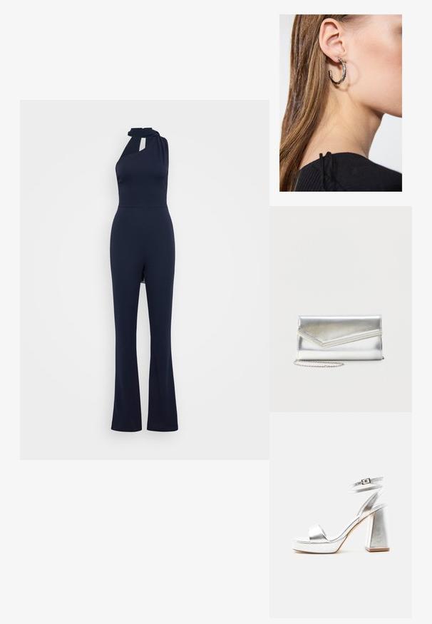 Mono sin mangas de color azul marino con cuello halter, detalle en forma de ojo de cerradura en la parte frontal, cuerpo ajustado y diseño de pierna acampanada en una tela suave.; Sandalia de tacón alto plateada metálica con tira en el tobillo, tacón de bloque y punta abierta sobre un fondo claro y liso.; Bolso clutch plateado brillante con solapa de estilo sobre y adorno decorativo, pequeña correa de cadena plateada, sobre fondo liso claro.; Pendiente de aro de plata con un acabado pulido, que presenta pequeños detalles en dorado y una forma redonda, llevado en el lóbulo.