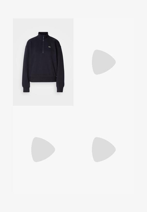 Sudadera azul marino con cuello alto y cremallera de cuarto, presenta mangas largas y un dobladillo acanalado. Incluye un pequeño logotipo verde en el pecho.; Camiseta blanca de algodón con mangas cortas, escote redondo y un sutil logo bordado en el pecho. Textura suave, corte clásico.; Pantalones jogger blancos con cintura elástica y cordón, que cuentan con bolsillos laterales y puños acanalados. Tela suave con detalle de logo bordado.; Zapatilla baja blanca con cordones blancos, logo de cocodrilo verde en el lateral y etiqueta "Lacoste" en la suela, sobre un fondo neutro.