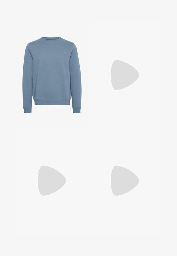 Sweat-shirt bleu en tissu doux et texturé. Design à col rond, manches longues et poignets côtelés. Détail du logo discret sur le devant.; Chemise bleu clair à col, manches longues et texture subtile ; présente un petit logo sur la zone du sein gauche.; Pantalon en coton bleu marine avec une coupe droite, doté d'une fermeture à boutons à l'avant et de poches latérales visibles. Texture lisse.; Chaussure d'homme en cuir tan à lacets avec bout mocassin, col matelassé et semelle en caoutchouc épaisse, vue de côté sur un fond uni.