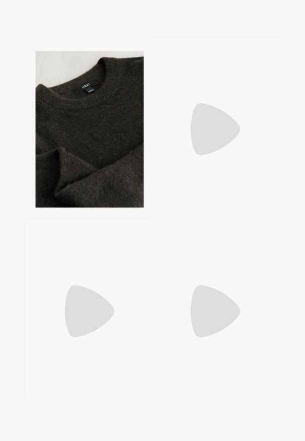 Bruine trui van een fuzzy textuur, met een ribbelgebreid ronde hals en het merklabel "NEXT" aan de binnenkant van de kraag.; Blauwe losse denim broek met elastische taille en enkelsluitingen, met riemlussen en subtiele voorste naaddetails.; Bruine suède instapschoenen met een gestikt moccasin-neus, platte zwarte rubberen zool en een decoratieve bovenband en detail.; Gouden vierkante horloge met witte wijzerplaat, zwarte Romeinse cijfers en dubbele zwarte leren band met witte stiksels, merk Fossil.