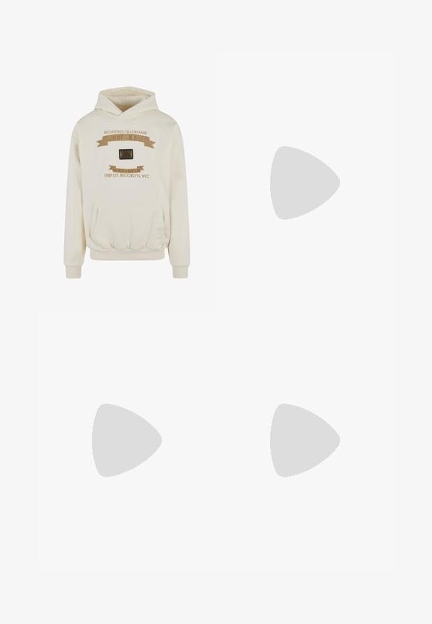 Cremefarbener Hoodie mit einer frontalen Kängurutasche, gerippten Bündchen, dekorativer goldener Stickerei und einem rechteckigen schwarzen Logopatch auf der Brust.; Camo-Shorts aus Baumwollmischung mit grünem, braunem und beigem Muster. Verfügt über einen elastischen Taillenbund mit Kordelzug. Lässiger Schnitt und knielange Form.; Beiger Nike Air Force 1 Sneaker schwebt über einer grauen Betonplatte mit unscharfem Treppenhintergrund.; Schwarze rechteckige Sonnenbrille mit dicken Rahmen und dunkel getönten Gläsern auf einer weißen Oberfläche aus einem Winkel betrachtet.