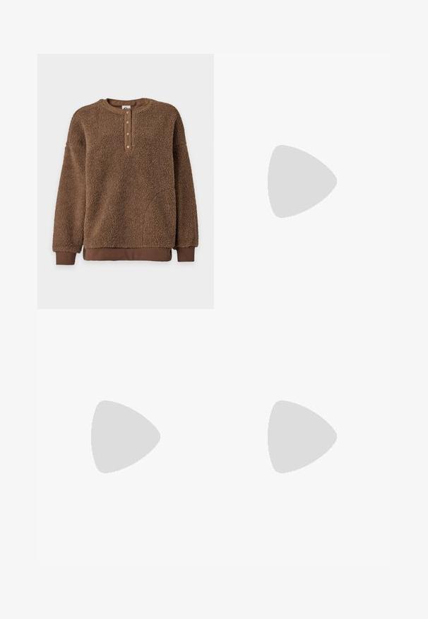 Bruine fleece pullover met lange mouwen, een ronde hals, vier drukknoopsluitingen aan de voorkant en geribde boorden en zoom.; Wit shirt met lange mouwen en ronde hals met klein zwart The North Face-logo op de linkerborst.; Lichtgroene cargobroek met wijde pijpen, gemaakt van katoen. Bevat twee zijzakken en een knoopsluiting. Soepele textuur en casual ontwerp.; Zwarte canvas sneaker met een witte rubberen platformzool, voorzien van witte veters en stiksels, iconische branding op de zijkant, low-top ontwerp.