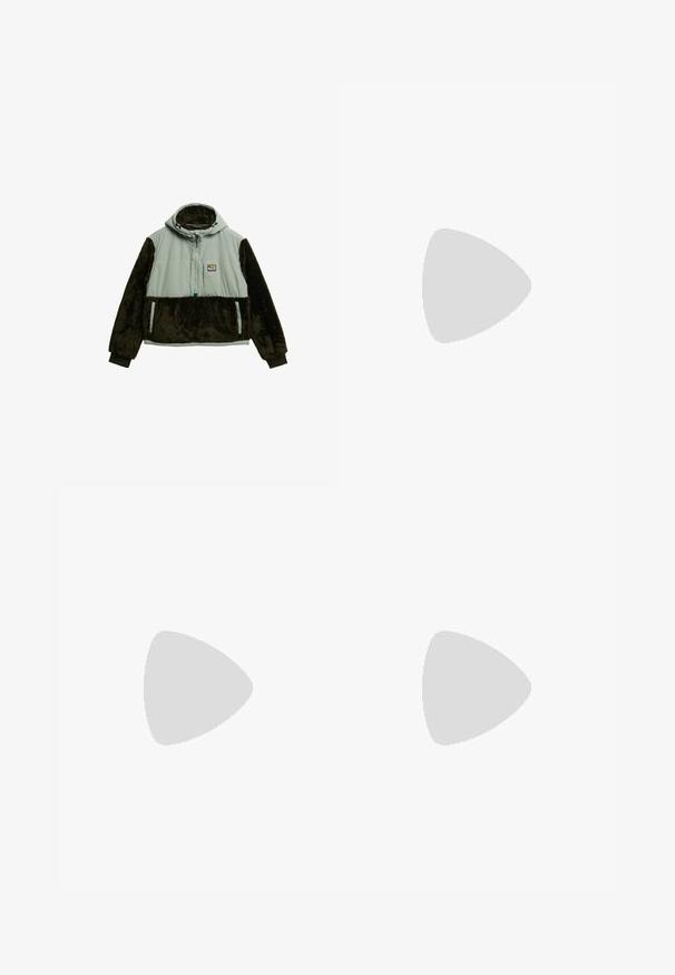 Veste à capuche avec une partie supérieure gris clair et des manches inférieures en fausse fourrure marron foncé. Elle comporte une fermeture éclair à l'avant et deux poches latérales.; Pantalons avec une ceinture, présentant un mélange de tissus vert foncé et gris, un design de patchwork angulaire, plusieurs poches et des sangles de cheville ajustables.; Bottes cheville en denim noir à tige haute, avec une surface texturée, une semelle en caoutchouc gomme contrastante, et des lacets ronds.; Sac à dos gris foncé à fermeture roulante avec poche avant à fermeture éclair, sangles de compression latérales et compartiment inférieur à fermeture éclair, présenté sur fond blanc.