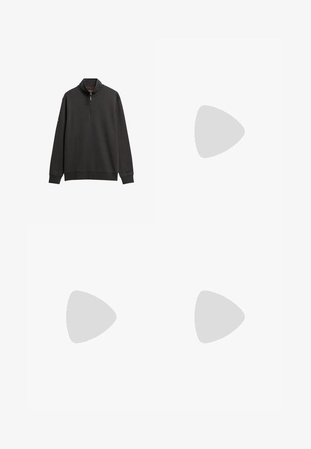 Donkergrijze sweatshirt met hoge kraag, halve rits en lange mouwen. Heeft contrasterende stiksels en subtiele logo-details op de kraag.; Grijze katoenen T-shirt met korte mouwen, ronde hals, featuring horizontale strepen in blauw, wit en groen over de borst, met opdruk van het logo.; Donkergrijze denim jeans met een reguliere pasvorm. Kenmerken zijn vijf zakken, een ritssluiting en subtiele vervaging op de stof voor textuur.; Beige suède sneaker met veters en "ck"-logo, zwevend boven een gepolijste betonnen vloer met een achtergrond van glazen blokken.