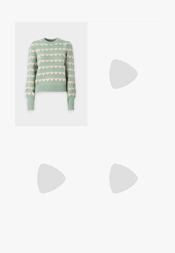 Muntgroene gebreide trui met witte hartpatronen, geribde manchetten en zoom, ronde halslijn en licht poffende mouwen.; Blauwe denim wijde jeans met een hoge taille, vijf zakken, sluiting met een knop aan de voorkant en een licht vervaagde afwerking. Gestikte zomen en naden zijn zichtbaar.; Zwarte leren instappers met een chunky, gestructureerde zool, voorzien van een band over de voet en een gladde, gepolijste afwerking.; Vrouw met lang donker haar in een zwart pak, met een zwart leren schoudertas, die over haar schouder kijkt tegen een witte achtergrond.