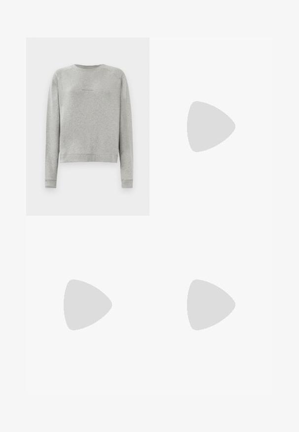 Grijze sweatshirt met lange mouwen, ronde halslijn en ribgebreide manchetten. Heeft een subtiel logo op de voorkant. Zachte, gestructureerde stof.; Lichtroze T-shirt met korte mouwen en een ronde hals, voorzien van een subtiel overal ingebosseleerd tekstpatroon en een klein verhoogd logo op het midden van de borst.; Wijdvallende jeans in een lichtbeige kleur met vervaagde, versleten accenten. Bevat vijf zakken en een metalen knoopsluiting in de taille.; Roze suède sneakers met bijpassende strepen, witte veters en een crèmekleurige zool. Gecombineerd met witte sokken en losse bruine broeken op een gele achtergrond.